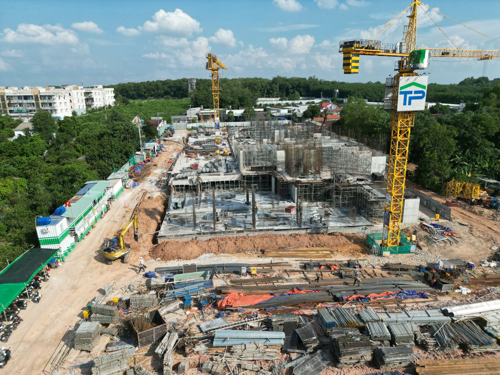 Drone photograph of an active construction site with concrete structures, cranes, and staged materials